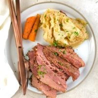 a plate of corned beef, cabbage and carrots
