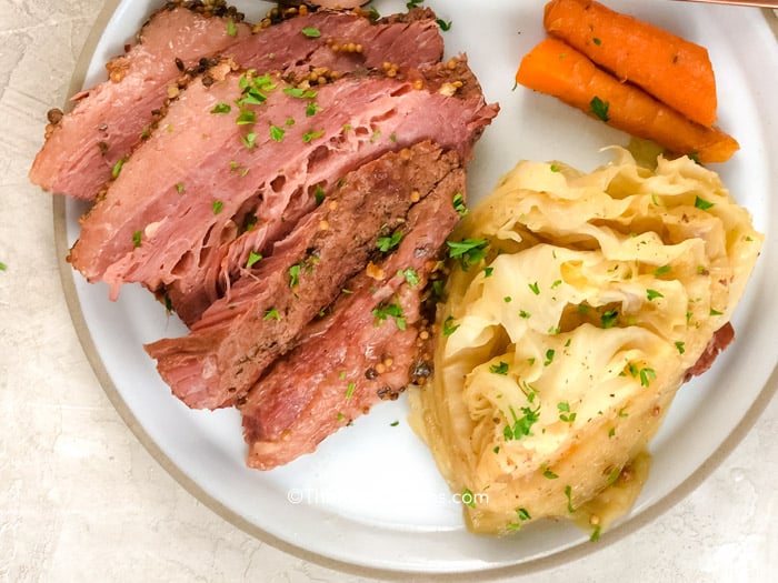 a plate of corned beef and cabbage with a fork and knife